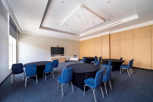 a conference room with tables and chairs and a tv at Radisson Hotel Riyadh Airport in Riyadh
