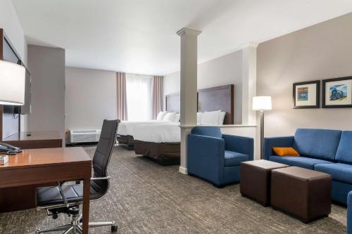 een hotelkamer met een bed, een bureau en stoelen bij Comfort Suites in Paducah