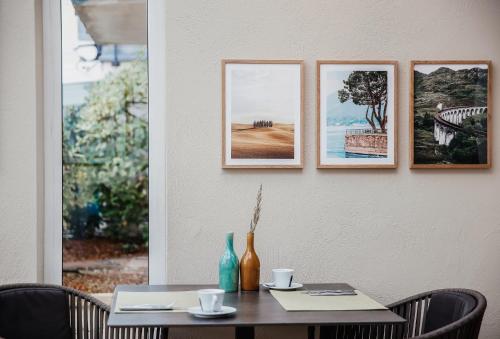 a table with four pictures hanging on a wall at Villa Bosco - Boutiquehotel in Walldorf