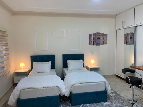 a bedroom with two beds and two lamps at Tayoon Host in Jerash