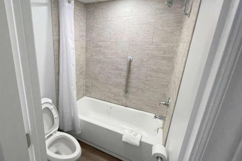uma casa de banho com uma banheira, um WC e um chuveiro em Super 8 by Wyndham Pigeon Forge Downtown em Pigeon Forge