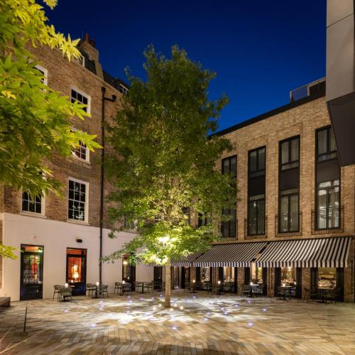 a tree in a courtyard in front of a building at Sun Street Hotel Shoreditch in London