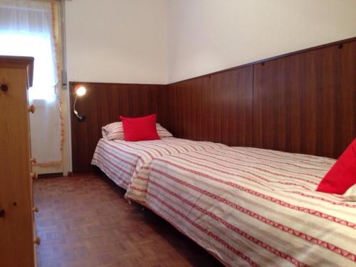 a bedroom with a bed with red pillows on it at Casa ai Dossi in Bellamonte