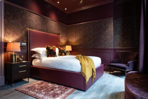 a bedroom with a large bed and a purple wall at Sun Street Hotel Shoreditch in London