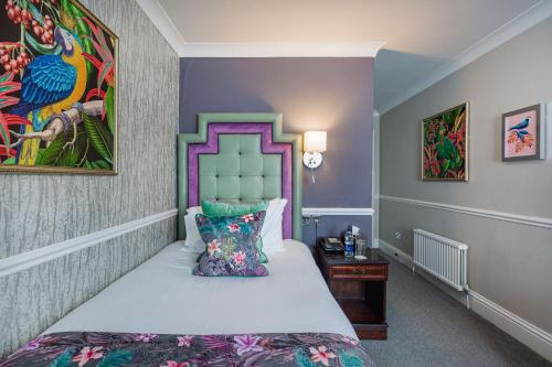 a bedroom with a bed and a painting on the wall at The Crown Hotel, Boroughbridge, North Yorkshire - The Coaching Inn Group in Boroughbridge