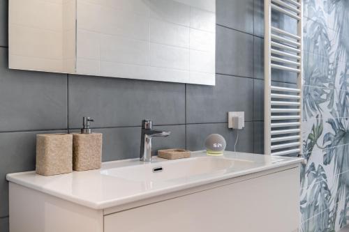 een badkamer met een witte wastafel en een spiegel bij Scuole CEMM San Vito Apartment with parking in Taranto
