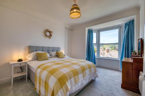 a bedroom with a bed and a large window at Brent House - 4 bedroom home close to shops, harbour & beaches in Ilfracombe