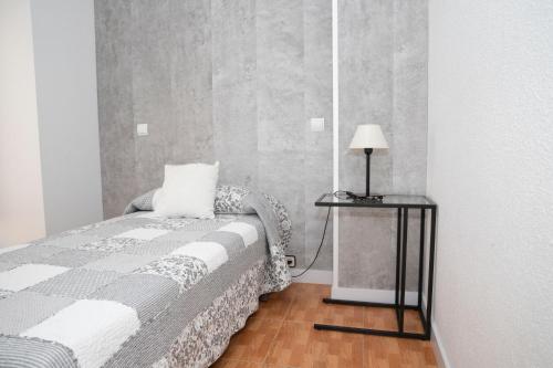 sypialnia z łóżkiem i stołem z lampką w obiekcie Hostal Tokio w Madrycie