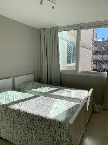 two beds in a bedroom with a window at Departamento Villa Los Remeros, Tigre in Tigre