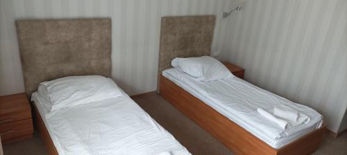 two beds in a small room withskirts at Hotel Przylesie in Sierosław