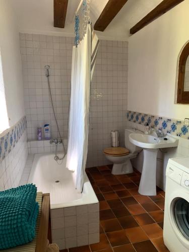 łazienka z wanną, umywalką i toaletą w obiekcie Can Carreras w mieście Monells