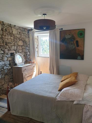 ein Schlafzimmer mit einem großen Bett und einem Fenster in der Unterkunft Maison de village avec piscine au-dessus des Cinque Terre in Madonna del Trezzo