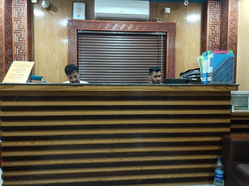 two men sitting at a counter in an office at Hotel As Shams International in Dhaka