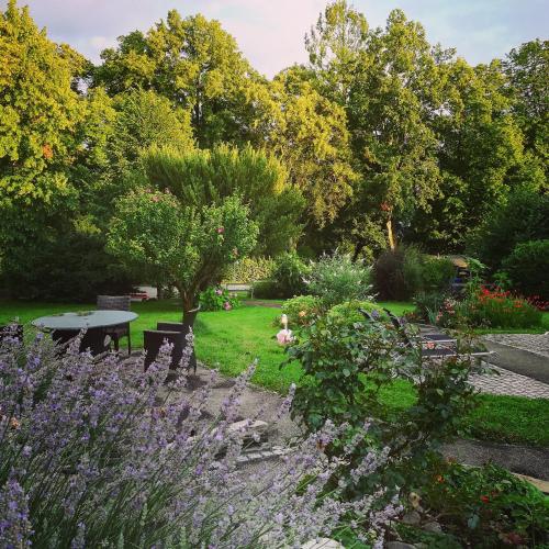 a garden with a table and chairs and purple flowers at Hotel Lindenallee in Lindau