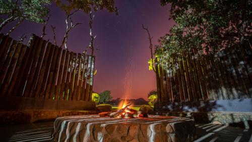 una mesa con fuego delante de una valla en Kilima Private Game Reserve & Spa, en Gravelotte
