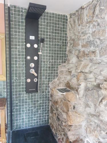 eine Dusche mit einer Steinmauer im Bad in der Unterkunft Maison de village avec piscine au-dessus des Cinque Terre in Madonna del Trezzo