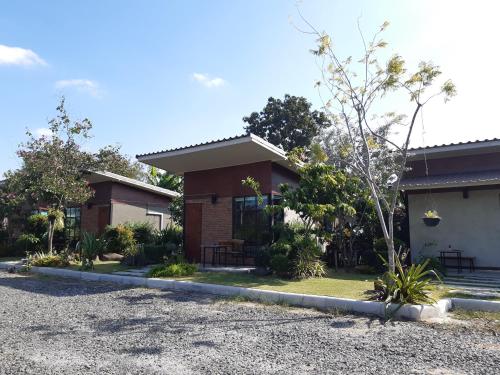 una casa con una entrada de grava delante de ella en Vwara Resort, en Buriram