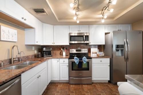 a kitchen with white cabinets and stainless steel appliances at Desert Paradise in Arcadia ~ Pool, Hot Tub, Views! in Phoenix