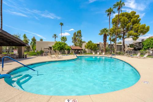 a large pool with blue water and palm trees at Desert Paradise in Arcadia ~ Pool, Hot Tub, Views! in Phoenix