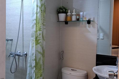 La salle de bains est pourvue d'une douche, de toilettes et d'un lavabo. dans l'établissement Condo Deluxe near NAIA Terminal 3, à Manille