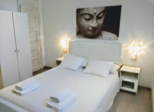 una camera da letto con un letto bianco e un dipinto sul muro di Ocean and pool view - Apartamento Parque Santiago 2 ad Arona