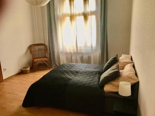 Schlafzimmer mit einem schwarzen Bett und einem Fenster in der Unterkunft Apartmán u kostela in Turnov