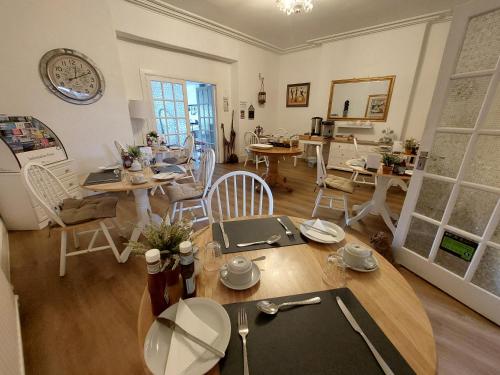 een woonkamer met een tafel en stoelen bij Beachcomber B&B in Tenby