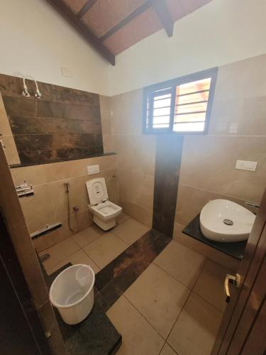 a bathroom with a toilet and a sink at Aashirvada in Chikmagalūr