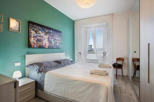 1 dormitorio con cama blanca y pared azul en Sweet Chloe Milano, en Milán