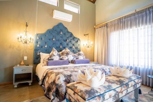 a bedroom with a large bed with a blue headboard at Kilima Private Game Reserve & Spa in Gravelotte