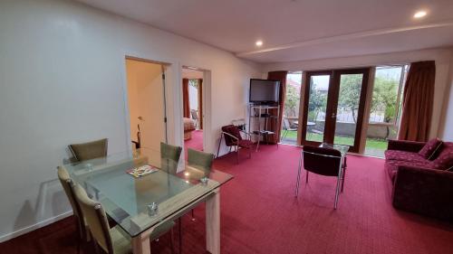 a living room with a glass table and chairs at Chantillys Motor Lodge in Taupo