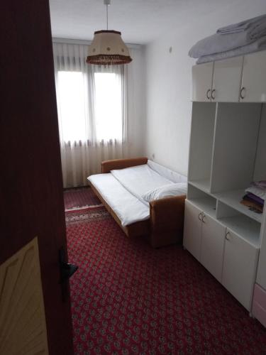 a small bedroom with a bed and a red carpet at Vila Borova Tara in Kremna