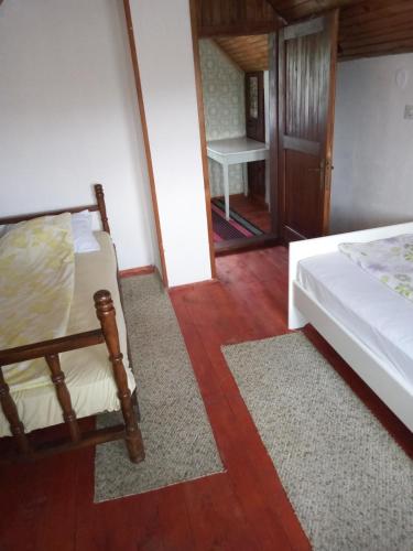 a bedroom with a bed and a wooden floor at Vila Borova Tara in Kremna