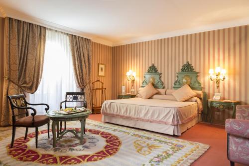 a bedroom with a bed and a table and a chair at Eurostars Hotel de la Reconquista in Oviedo