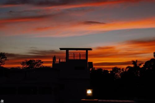 a silhouette of a building with a sunset in the background at Dianna’s Inn in Coron