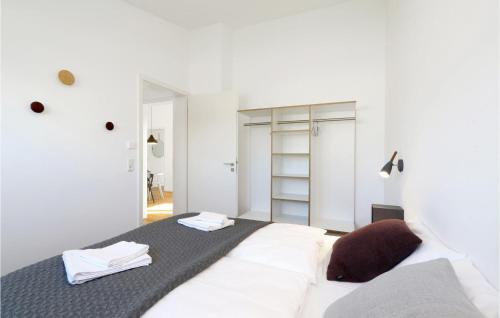a white room with a bed and a mirror at Awesome Home In Lembruchdümmer See in Lembruch