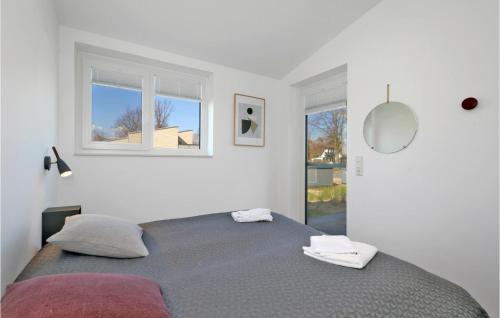 a bedroom with a bed and two windows at Awesome Home In Lembruchdümmer See in Lembruch