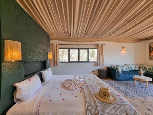 a bedroom with a large bed with a wooden ceiling at Villa Katia in El Harkat