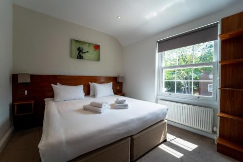 um quarto com uma grande cama branca e uma janela em Chelsea Guest House em Londres