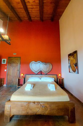 a bedroom with a large bed in a red wall at Metohi in Marioláta