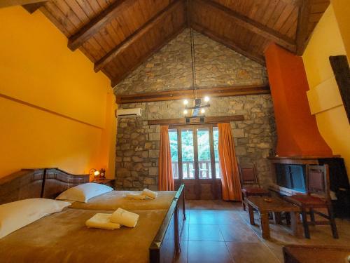 a bedroom with a large bed and a stone wall at Metohi in Marioláta