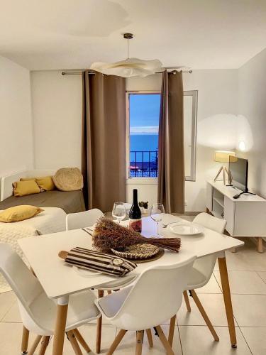 - une table et des chaises dans le salon avec vue sur l'océan dans l'établissement Domaine a Mortella, à Saint-Florent