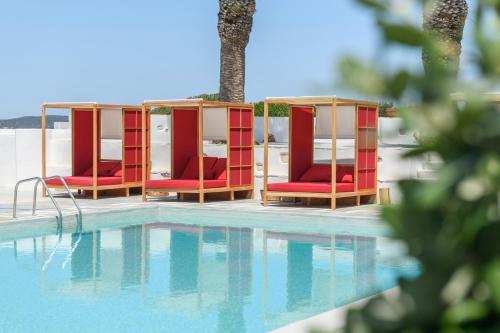 a group of red chairs next to a swimming pool at Kallisti Paros in Naousa