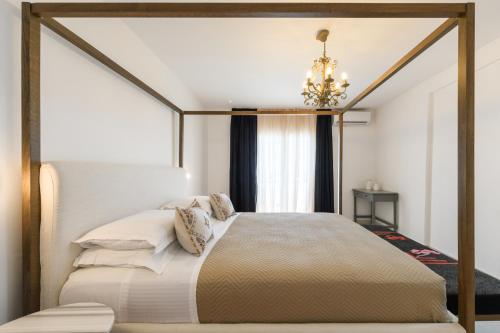 a bedroom with a canopy bed with a chandelier at Kallisti Paros in Naousa
