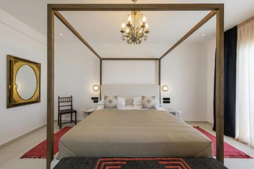 a bedroom with a canopy bed with a chandelier at Kallisti Paros in Naousa