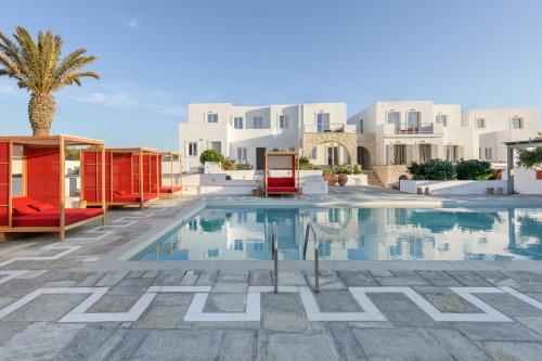 a swimming pool in a resort with white buildings at Kallisti Paros in Naousa