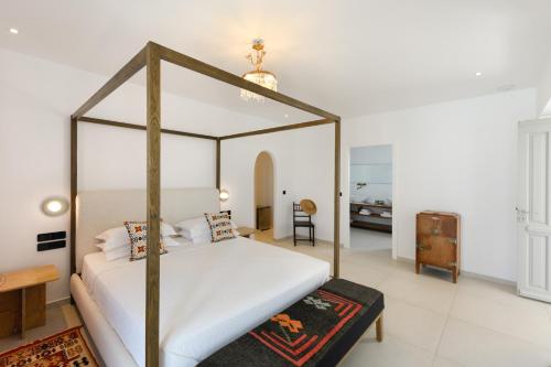 a bedroom with a canopy bed in a room at Kallisti Paros in Naousa