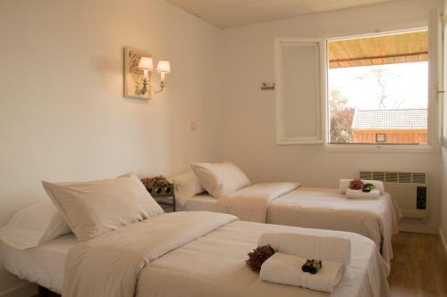 Habitación con 3 camas y ventana en Cabañas Navacerrada, en Navacerrada