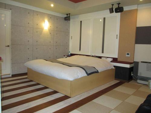 een slaapkamer met een groot bed en een televisie bij ホテル アルファ in Iizaka