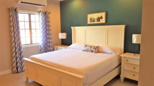 a bedroom with a large bed and a window at Sea Glass Villa Tobago in Golden Grove